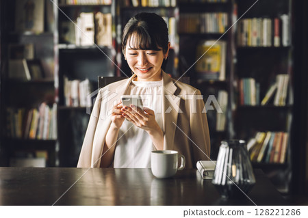 E-book, study, smartphone in library, Asian woman using smartphone, business woman 128221286