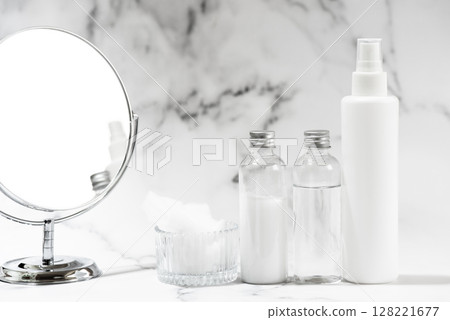 Plastic cosmetic bottles and a mirror on a marble background 128221677