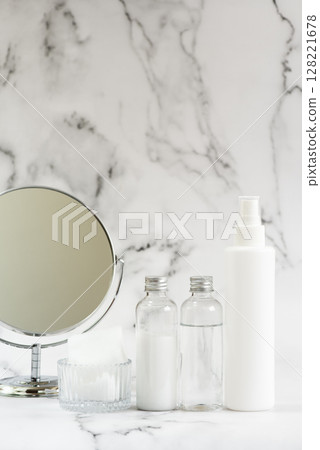 大理石背景上的塑膠化妝品瓶和鏡子的護膚圖像 128221678