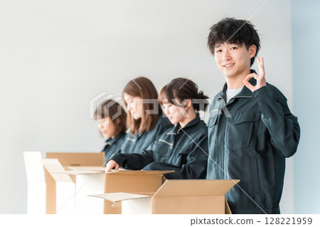 Male and female workers of transportation, logistics, courier, distribution, delivery, warehouse and delivery companies who pack items into cardboard boxes Male and female workers of transportation, logistics, courier, distribution, delivery, warehouse and delivery companies who pack items into cardboard boxes 128221959