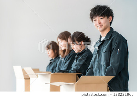 Male and female workers of transportation, logistics, courier, distribution, delivery, warehouse and delivery companies who pack items into cardboard boxes 128221963