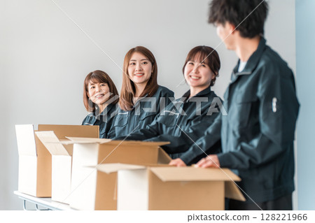 Male and female workers of transportation, logistics, courier, distribution, delivery, warehouse and delivery companies who pack items into cardboard boxes Male and female workers of transportation, logistics, courier, distribution, delivery, warehouse and delivery companies who pack items into cardboard boxes 128221966