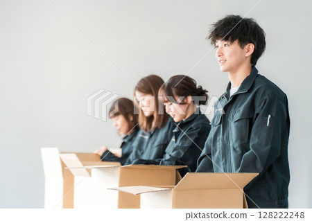 Male and female workers of transportation, logistics, courier, distribution, delivery, warehouse and delivery companies who pack items into cardboard boxes 128222248