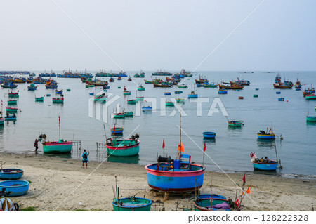 Colorful Basket Boats and Fishing Trawlers Anchored Off the Coast of Mui Ne, Vietnam Colorful Basket Boats and Fishing Trawlers Anchored Off the Coast of Mui Ne, Vietnam 128222328