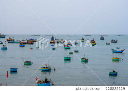 Traditional Boats and Basket Vessels Drifting on the Calm Sea of Mui Ne, Vietnam 128222329