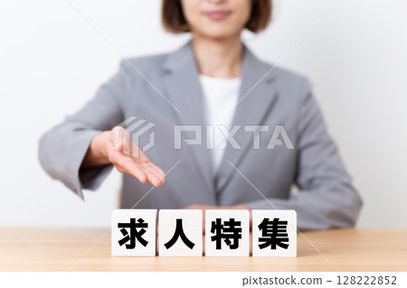 一位中年女商界女性穿著西裝,拿著工作邀請牌 一位中年女商界女性穿著西裝,拿著工作邀請牌 128222852