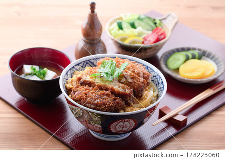 A colorful Japanese set meal with pork cutlet rice bowl, miso soup and salad 128223060