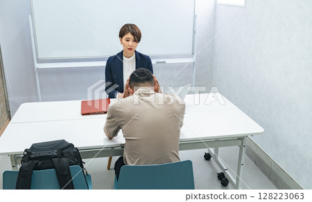 A Japanese female staff member interviewing a troubled black man 128223063