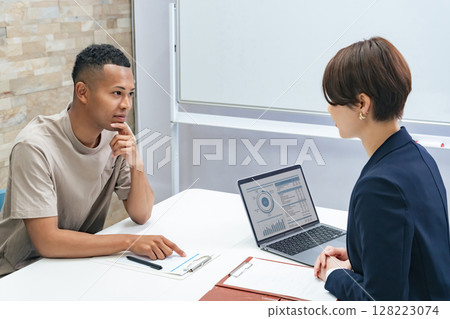 A black man and a Japanese female staff member having an interview 128223074