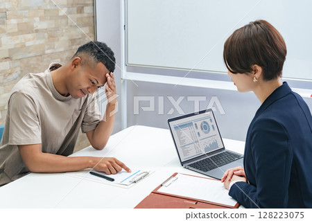 A Japanese female staff member interviewing a troubled black man 128223075