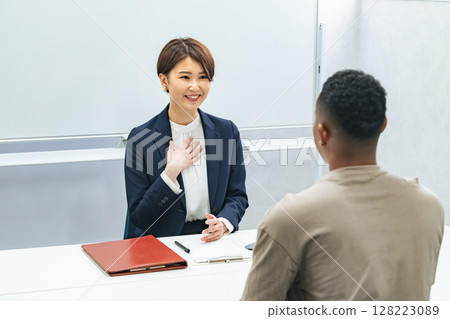 A Japanese female staff member interviewing a black man 128223089