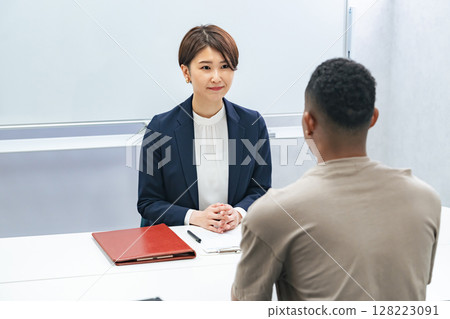 一名日本女工作人員正在採訪一名黑人男子 一名日本女工作人員正在採訪一名黑人男子 128223091