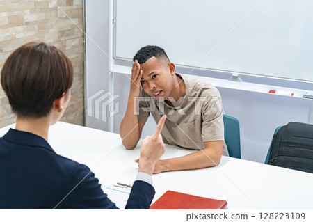 A Japanese female staff member interviewing a troubled black man A Japanese female staff member interviewing a troubled black man 128223109