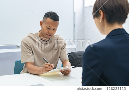 一名黑人男子和一名日本女工作人員簽署文件 128223113