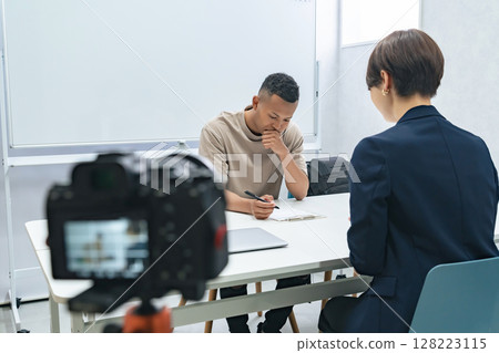 攝影機拍攝一名黑人男子與一名女工作人員的會面 攝影機拍攝一名黑人男子與一名女工作人員的會面 128223115