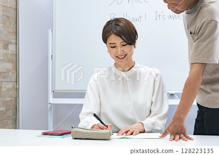 一名黑人男子和一名日本女子在教室裡交談 128223135