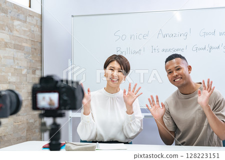 A black man and a Japanese woman filming a video 128223151