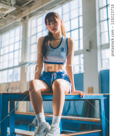 Female student in gym clothes sitting in gym Female student in gym clothes sitting in gym 128223718