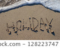 Soft wave washing away holiday writing on the beach sand 128223747