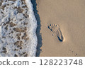 Footprint on the sand washed by the sea waves 128223748