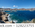 Waves crashing on the rocky coast of Karpathos on a sunny day, Greece 128223755