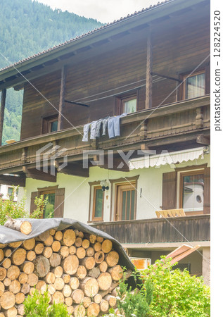Rustic wooden house with stacked firewood and laundry drying on balcony. High quality photo Rustic wooden house with stacked firewood and laundry drying on balcony. High quality photo 128224520