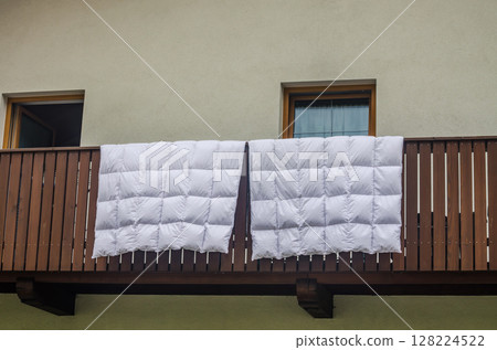 White Duvets Airing Out on Wooden Balcony of Alpine Home. High quality photo White Duvets Airing Out on Wooden Balcony of Alpine Home. High quality photo 128224522