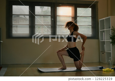 Morning workout routine with a fit woman practicing yoga at home Morning workout routine with a fit woman practicing yoga at home 128225319