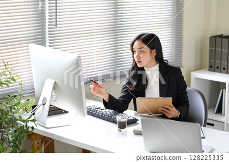 Businesswoman analyzing business performance and pointing to insights during a work 128225335