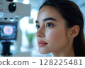 Young woman undergoing eye examination with modern equipment in clinic 128225481