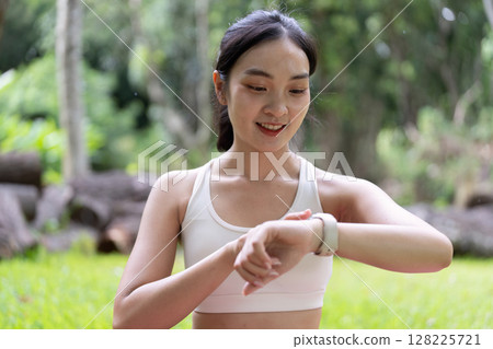Fitness Tracking. Smiling woman checking smartwatch after workout in nature. 128225721