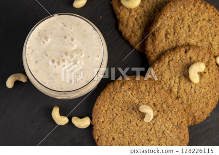 crunchy cookies and a glass of yogurt with prunes, a light breakfast of oatmeal cookies and a glass of yogurt, closeup crunchy cookies and a glass of yogurt with prunes, a light breakfast of oatmeal cookies and a glass of yogurt, closeup 128226115