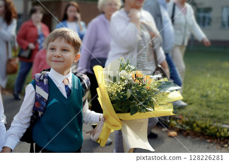 A 7-year-old boy carries a bouquet of flowers as he walks to his first day of school on September  128226281
