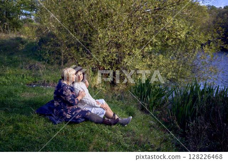 middle-aged daughter and an elderly mother together on a picnic in the autumn forest 128226468