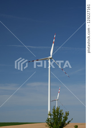 Two modern wind turbines in the countryside under a clear blue sky. Austria. 128227161