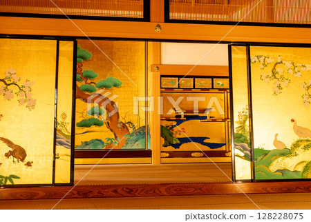 The gorgeous interior of Nagoya Castle's Honmaru Palace. A traditional Japanese space with beautiful golden sliding doors depicting pine trees, cherry blossoms, and birds. The gorgeous interior of Nagoya Castle's Honmaru Palace. A traditional Japanese space with beautiful golden sliding doors depicting pine trees, cherry blossoms, and birds. 128228075