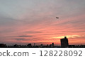 Airplane and sunset cityscape / Photo 128228092