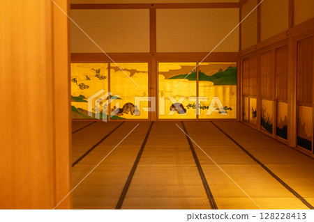 A tatami-floored hall in the Honmaru Palace of Nagoya Castle. A traditional Japanese-style space with animals and nature depicted on gold leaf sliding doors. A tatami-floored hall in the Honmaru Palace of Nagoya Castle. A traditional Japanese-style space with animals and nature depicted on gold leaf sliding doors. 128228413