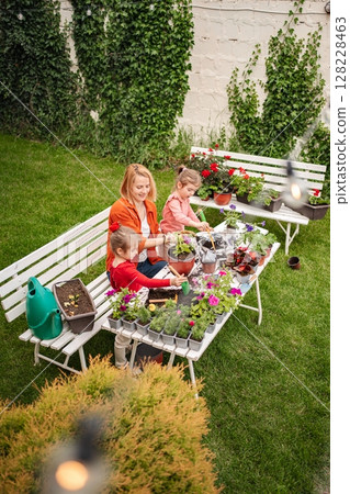 Gardening together in a vibrant backyard with family 128228463