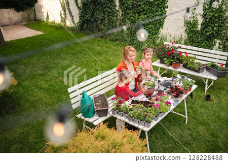 Gardening joys shared by family in a sunlit backyard 128228488