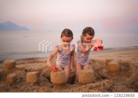 Joyful moments of creativity as family builds sandcastles at the beach Joyful moments of creativity as family builds sandcastles at the beach 128228688