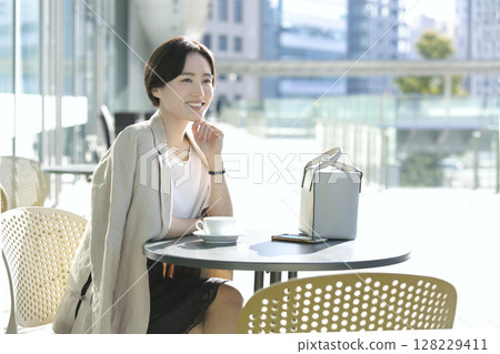 一位女士在咖啡館露臺上喝咖啡休息 128229411