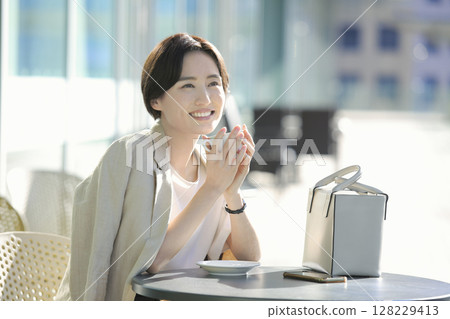 一位女士在咖啡館露臺上喝咖啡休息 128229413