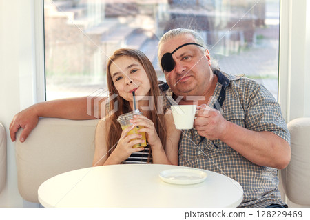 Father and daughter enjoying drinks at a cozy cafe together Father and daughter enjoying drinks at a cozy cafe together 128229469