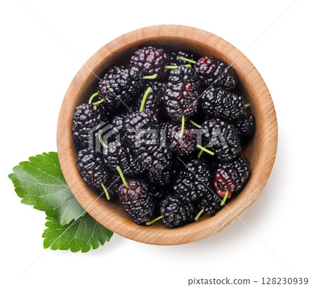 Mulberry in a wooden plate and leaves on a white background. Top view 128230939
