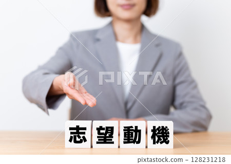 Middle-aged female business woman wearing a suit and a motivation block 128231218