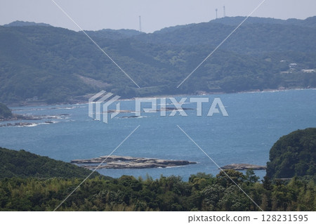 藍色海面海天景觀與綠色山脈和礁石 128231595