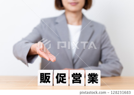 A middle-aged female business woman wearing a suit and a promotional sales block 128231683