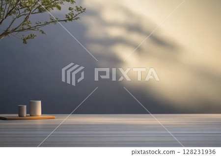 Shadows play softly on a minimalist table with ceramic cups under warm light 128231936