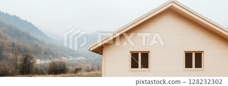 Beautiful wooden house in a serene mountainous landscape under a cloudy sky 128232302